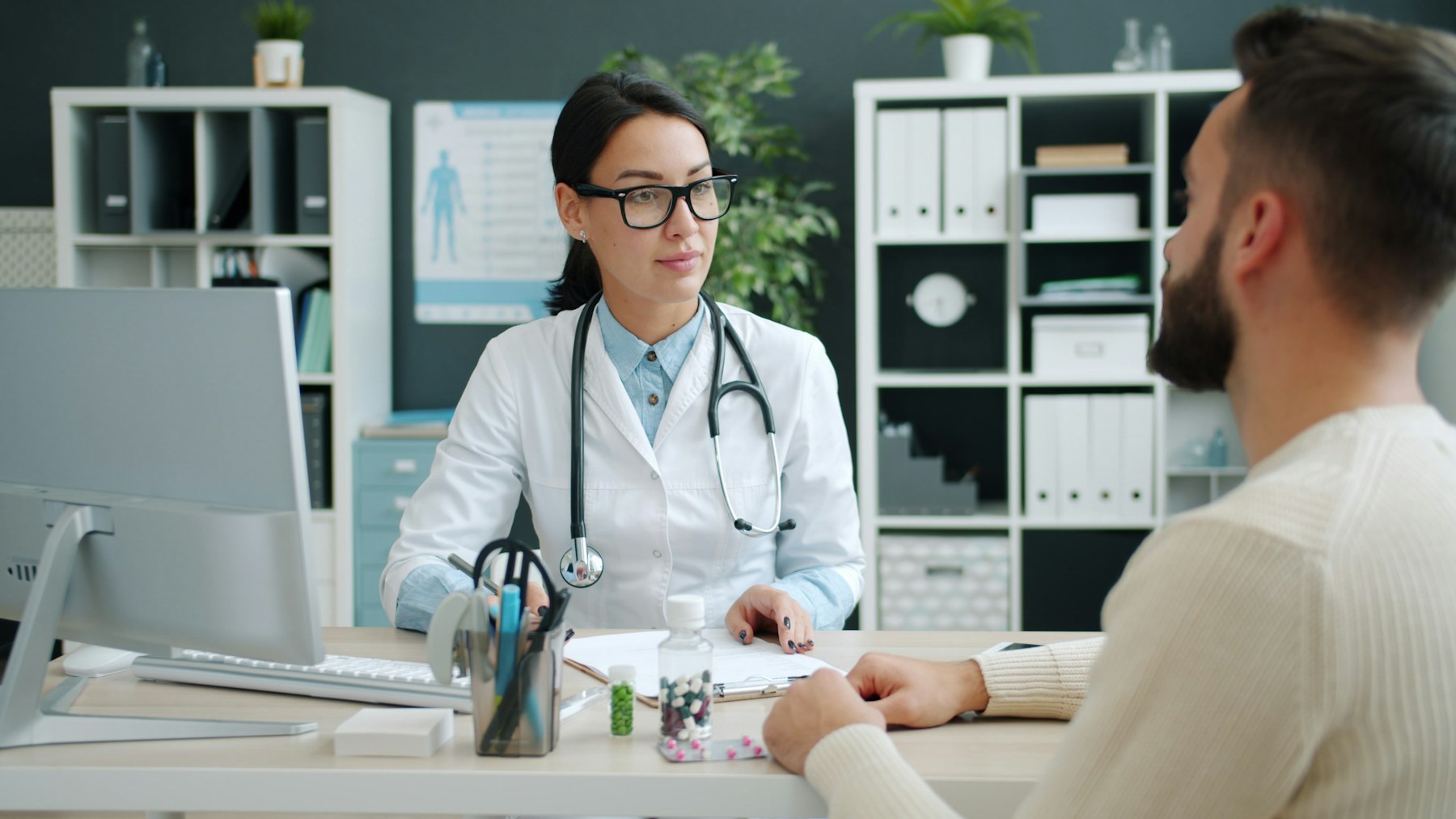 A doctor talking with a patient at a clinic desk