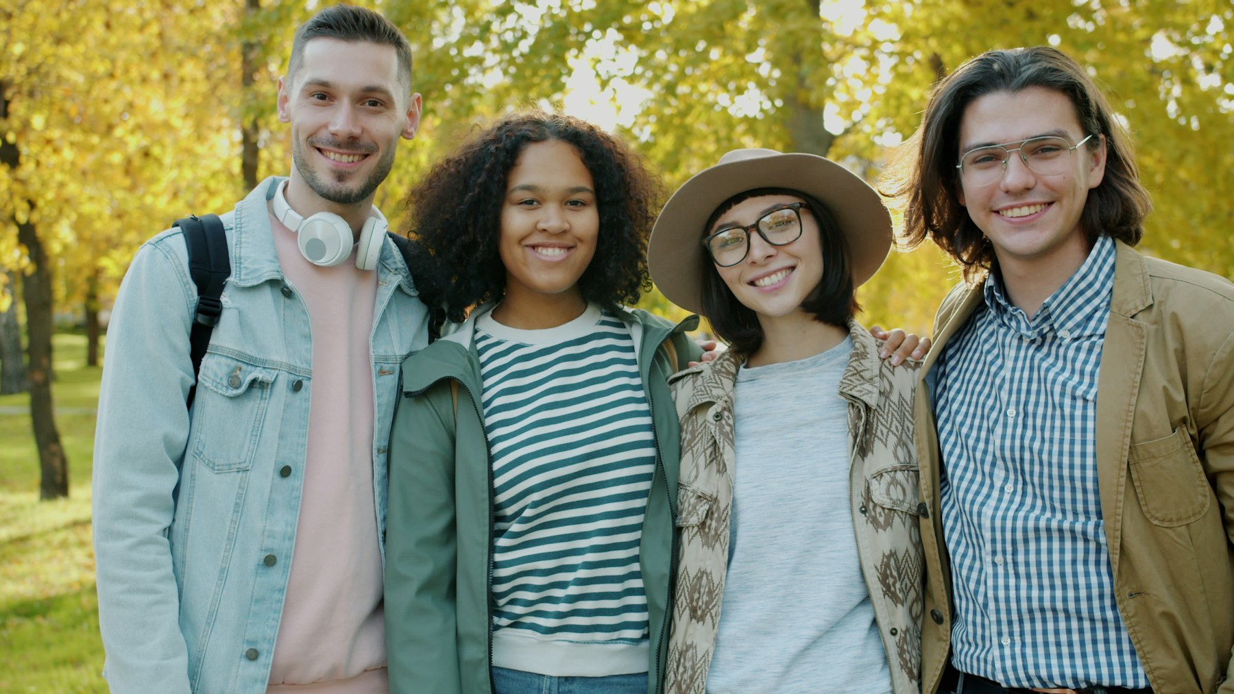 Four friends smiling together outdoors