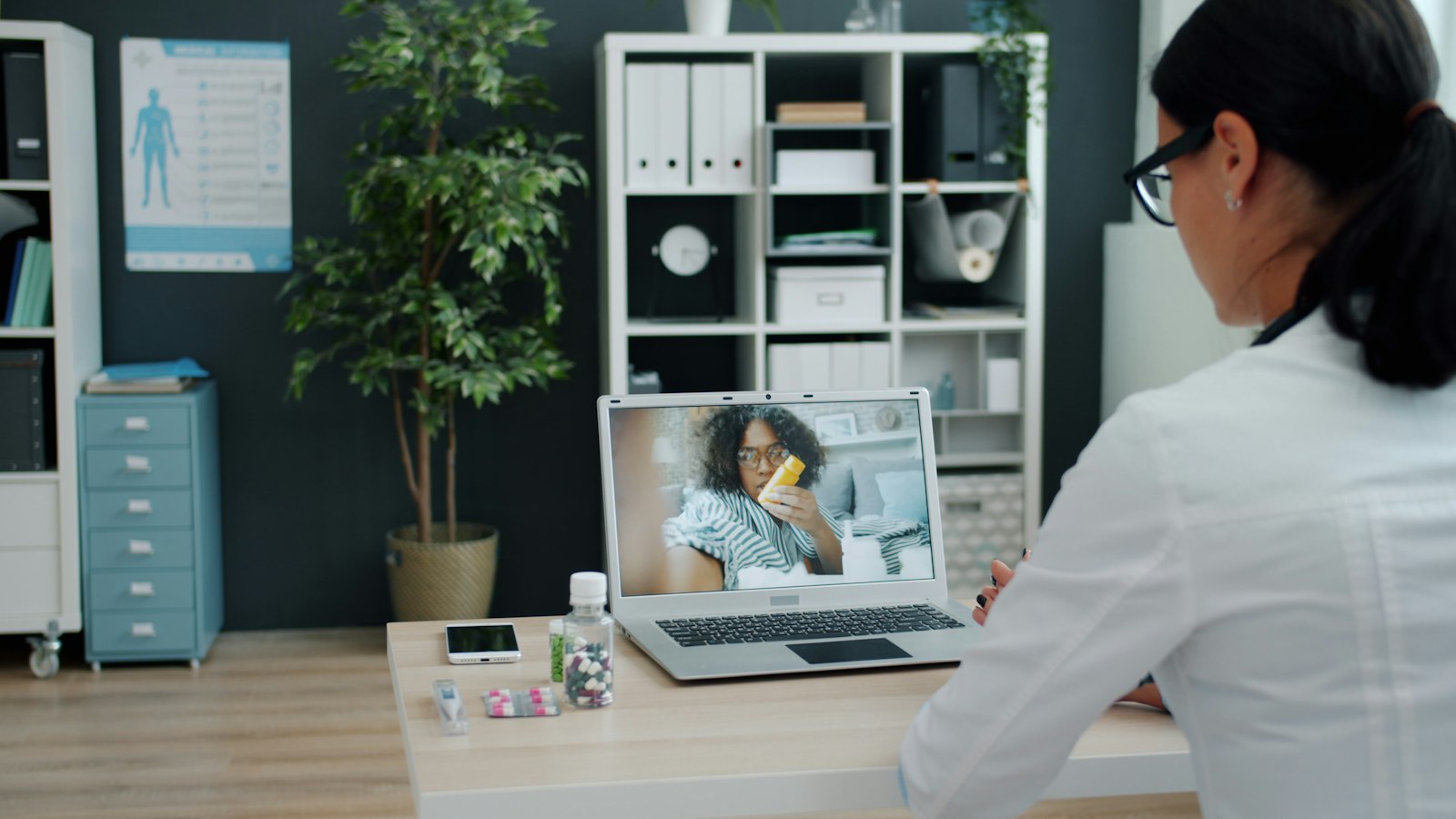 A doctor seeing a patient over a video call on a laptop
